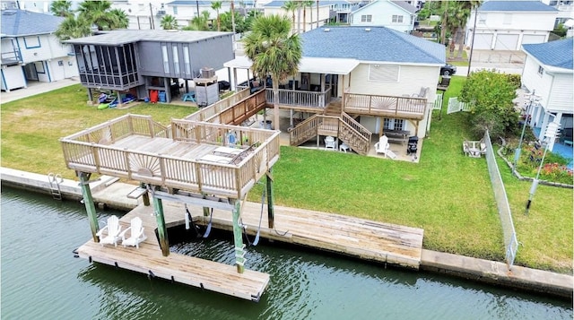 view of dock featuring a deck with water view and a yard