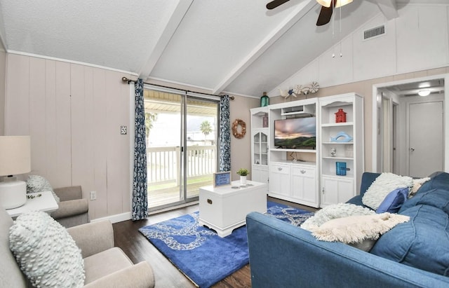 living room with lofted ceiling with beams, ceiling fan, dark wood-type flooring, and a textured ceiling