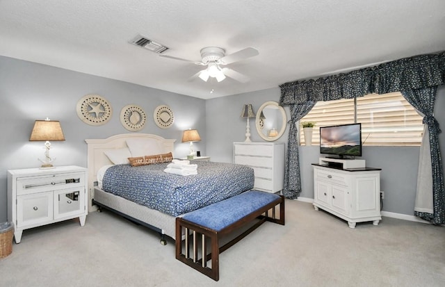 bedroom with light carpet, a textured ceiling, and ceiling fan