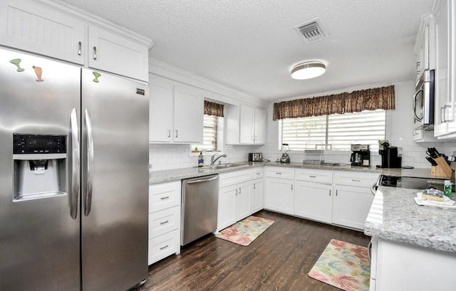 kitchen featuring white cabinetry, dark wood-type flooring, stainless steel appliances, and light stone counters