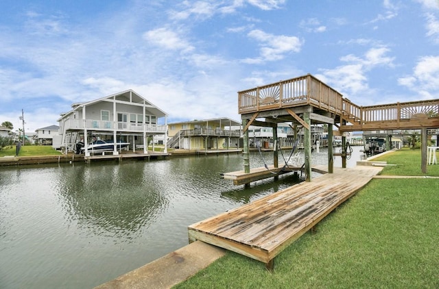 view of dock with a lawn and a water view