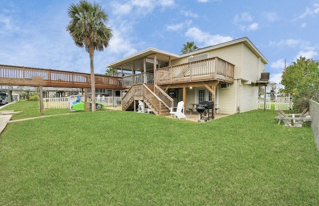 back of property featuring a lawn, a wooden deck, a sunroom, and a patio