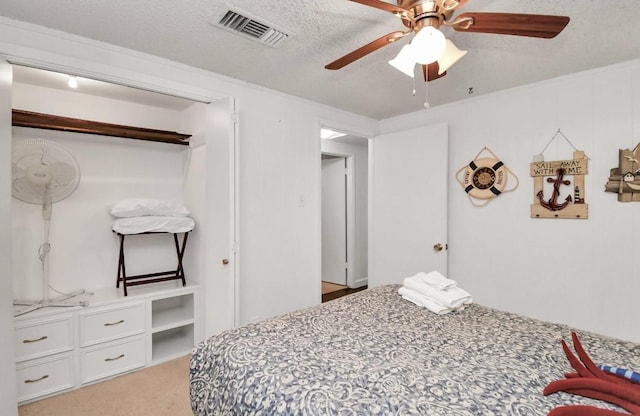 carpeted bedroom featuring a textured ceiling and ceiling fan