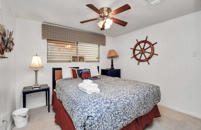 bedroom with ceiling fan, light colored carpet, and a textured ceiling