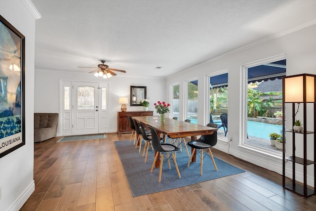 dining area with hardwood / wood-style flooring, crown molding, and ceiling fan