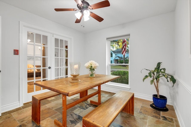 dining space with baseboards, ceiling fan, french doors, and stone tile floors