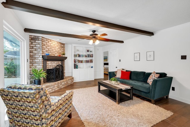 living room featuring baseboards, a ceiling fan, dark wood-style flooring, beamed ceiling, and a fireplace