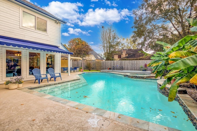 view of pool featuring a patio area, a fenced backyard, and a pool with connected hot tub