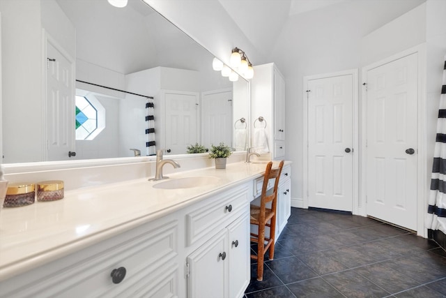 bathroom with double vanity, baseboards, curtained shower, vaulted ceiling, and a sink