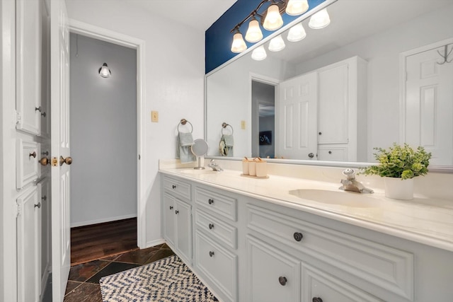 full bath featuring a sink, baseboards, and double vanity