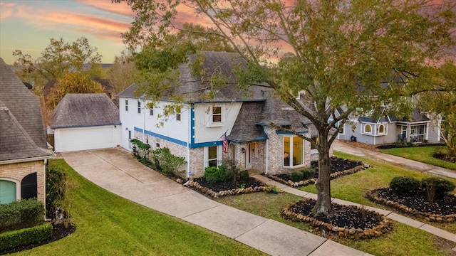 view of front of property featuring a yard, a shingled roof, an outdoor structure, and driveway