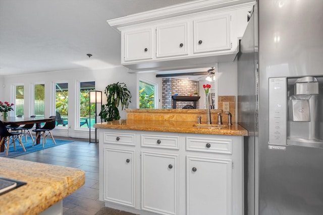 kitchen with white cabinetry, sink, and stainless steel fridge