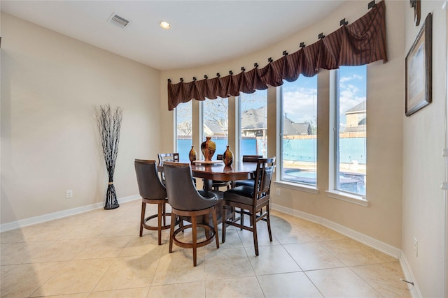 tiled dining room featuring a water view