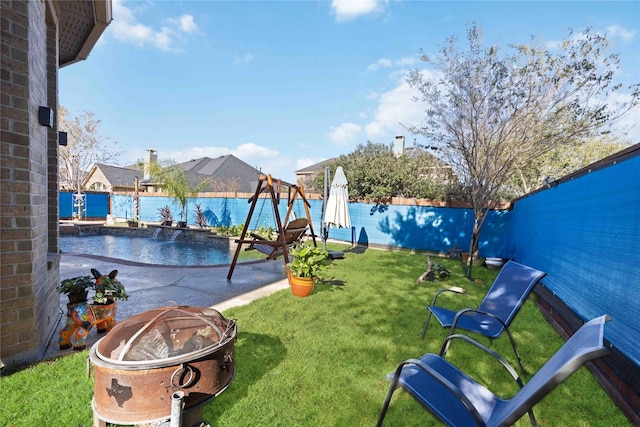 view of yard with a swimming pool and an outdoor fire pit