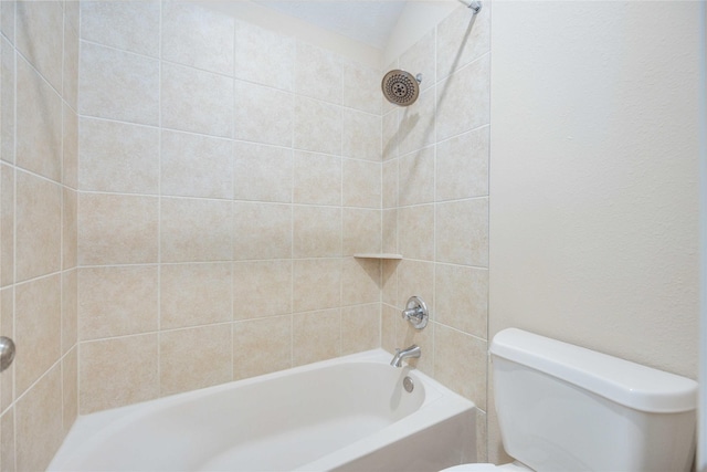 bathroom featuring tiled shower / bath combo and toilet