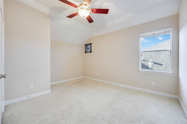 carpeted spare room with ceiling fan and lofted ceiling