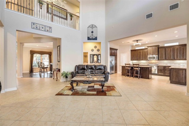 living room with light tile patterned flooring and a towering ceiling