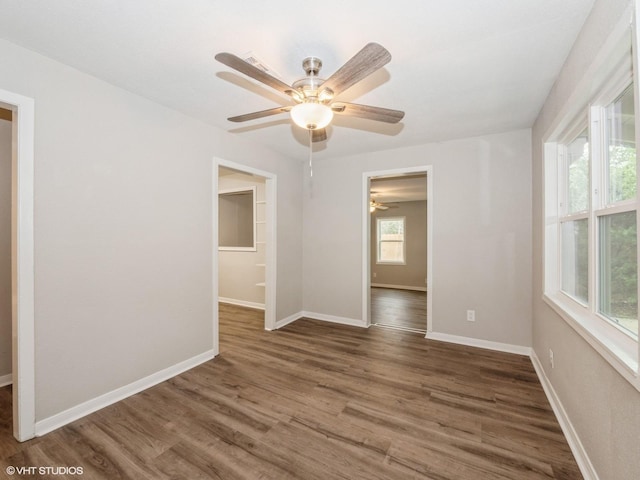 unfurnished room with dark hardwood / wood-style floors, a wealth of natural light, and ceiling fan