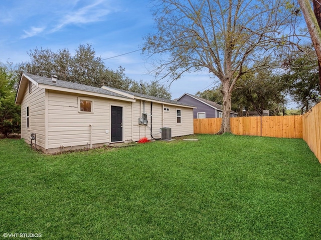 back of property featuring central air condition unit and a lawn