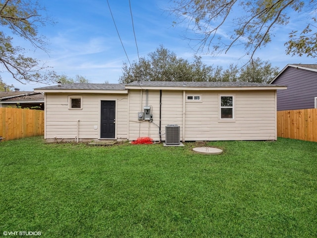 back of house featuring cooling unit and a lawn