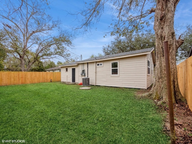 back of property featuring cooling unit and a lawn