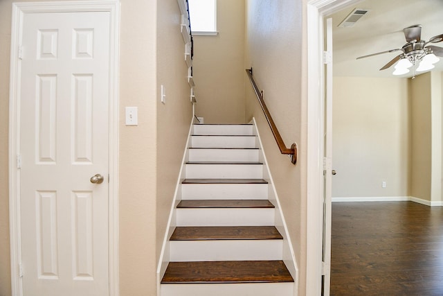 staircase featuring wood-type flooring and ceiling fan