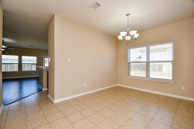 spare room with ceiling fan with notable chandelier and light hardwood / wood-style floors