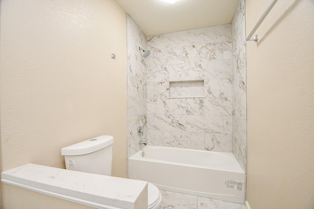 bathroom featuring tiled shower / bath and toilet