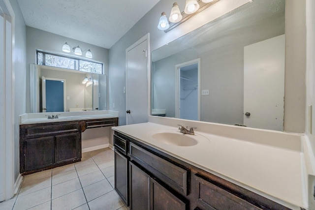 bathroom featuring tile patterned floors, vanity, and a textured ceiling