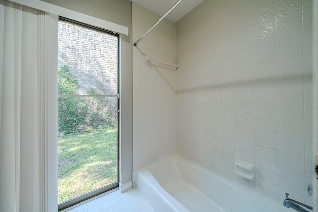 bathroom with shower / washtub combination, plenty of natural light, and tile patterned flooring