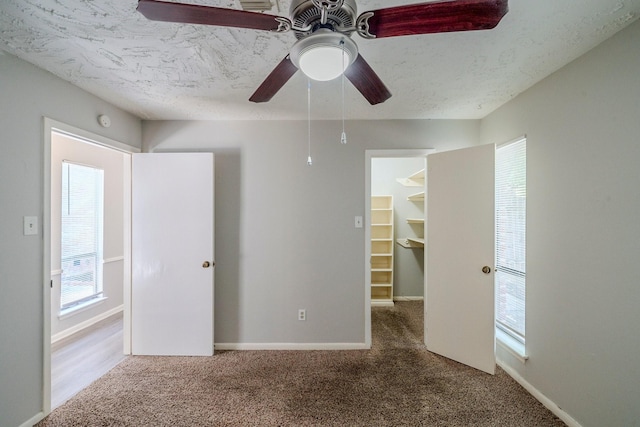 unfurnished room featuring ceiling fan, carpet floors, and a textured ceiling