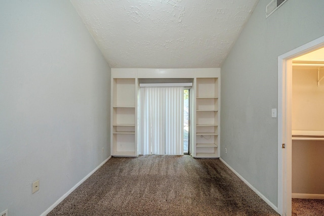 carpeted empty room featuring a textured ceiling