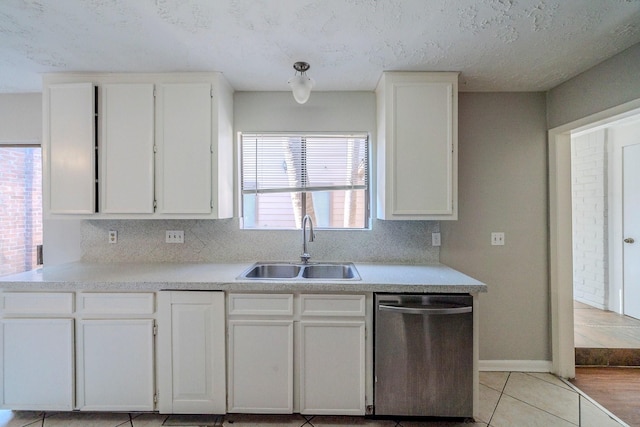 kitchen featuring dishwasher, sink, light tile patterned flooring, a textured ceiling, and white cabinets