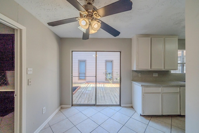 kitchen with backsplash, white cabinetry, ceiling fan, and light tile patterned flooring