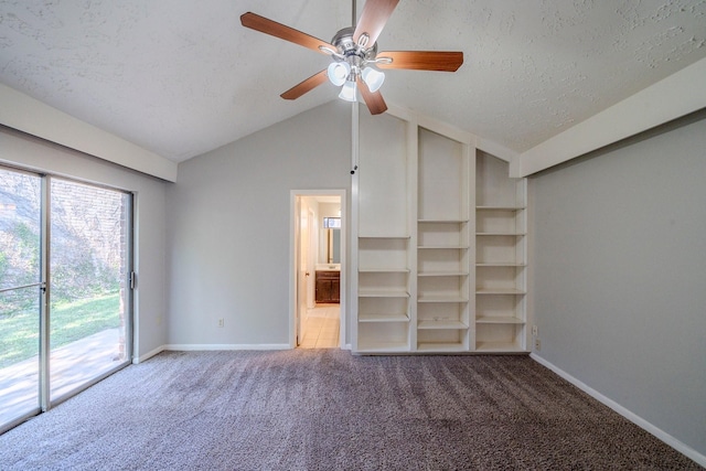 interior space featuring carpet flooring, a textured ceiling, vaulted ceiling, and ceiling fan