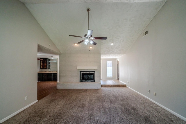 unfurnished living room featuring carpet, ceiling fan, and a brick fireplace