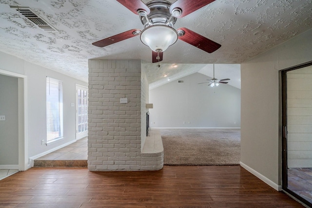 unfurnished living room featuring hardwood / wood-style floors, a textured ceiling, and lofted ceiling