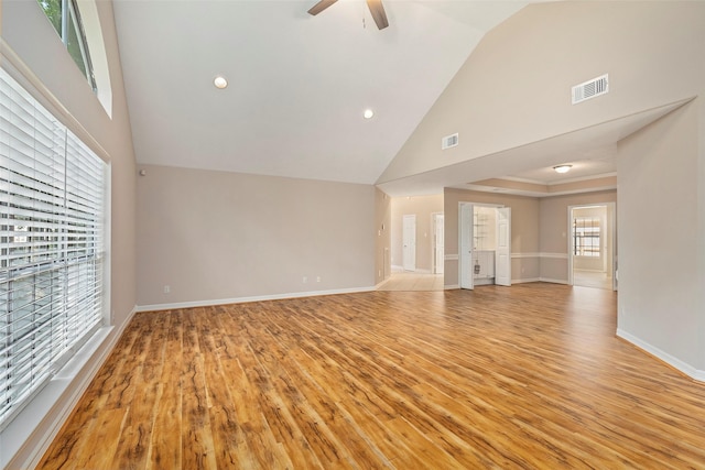 unfurnished living room with ceiling fan, high vaulted ceiling, and light hardwood / wood-style floors