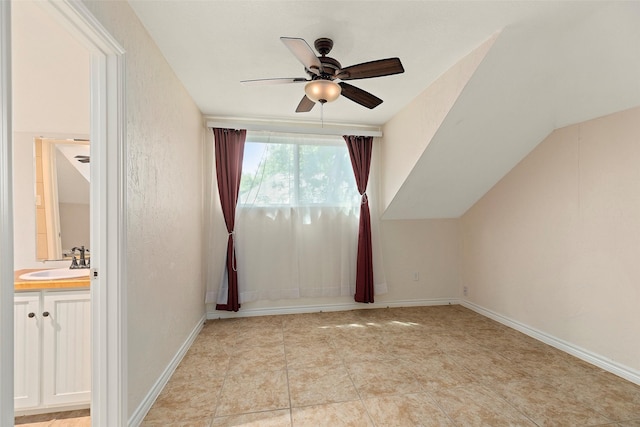 additional living space with ceiling fan, sink, and light tile patterned flooring