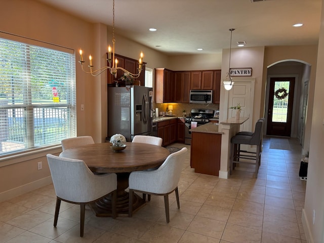 dining area with light tile patterned flooring and a chandelier