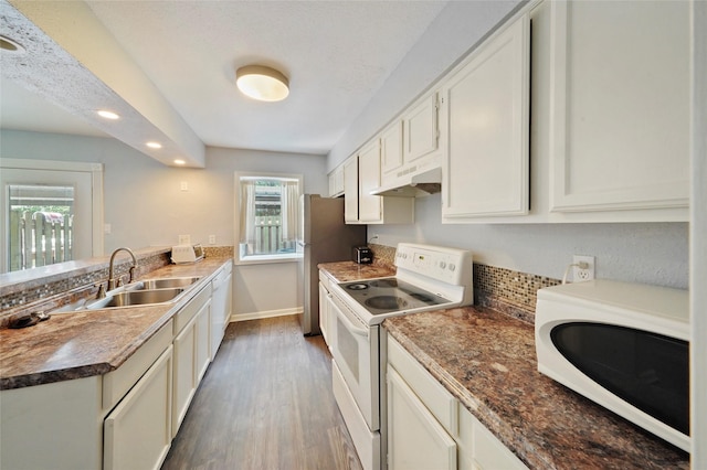 kitchen with dark wood-type flooring, sink, electric stove, white cabinets, and stainless steel refrigerator