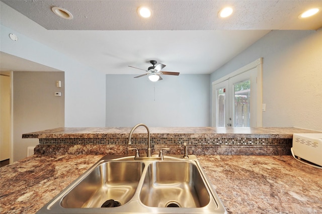 kitchen featuring french doors, a textured ceiling, ceiling fan, and sink