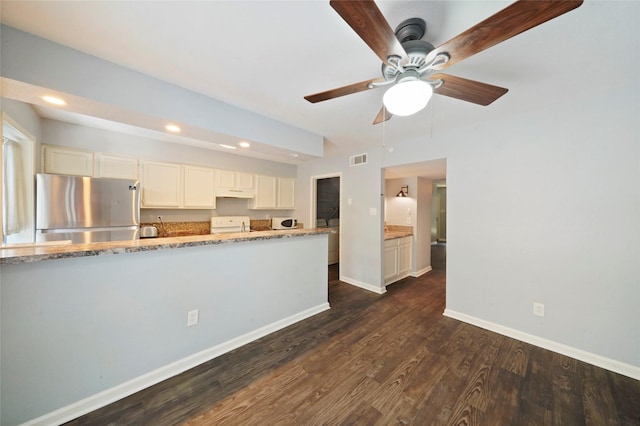 kitchen with stainless steel refrigerator, white cabinetry, dark hardwood / wood-style flooring, washer / clothes dryer, and stove