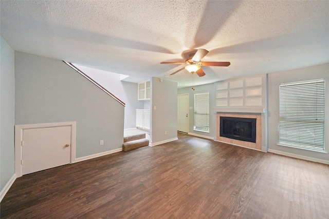 unfurnished living room with dark hardwood / wood-style floors, ceiling fan, and a textured ceiling