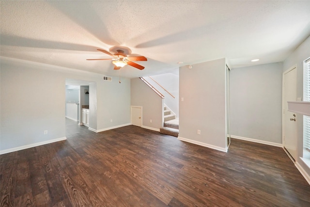 unfurnished living room with a textured ceiling, ceiling fan, and dark wood-type flooring