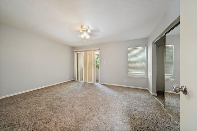 carpeted spare room featuring ceiling fan