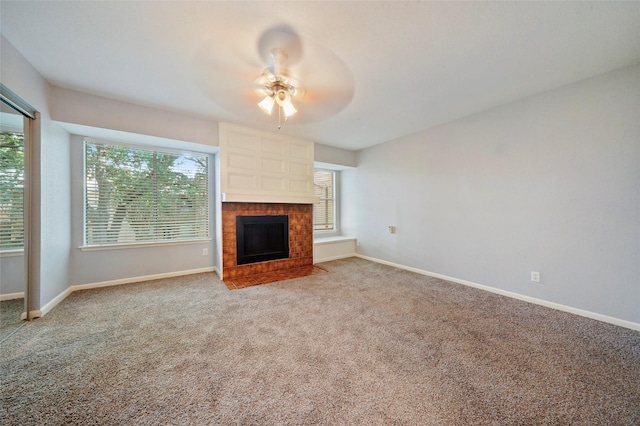 unfurnished living room featuring carpet flooring, a brick fireplace, and ceiling fan