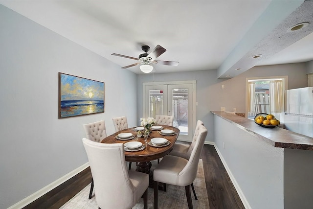 dining space featuring ceiling fan and dark hardwood / wood-style flooring