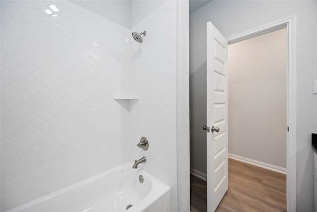 bathroom featuring tiled shower / bath combo and hardwood / wood-style flooring