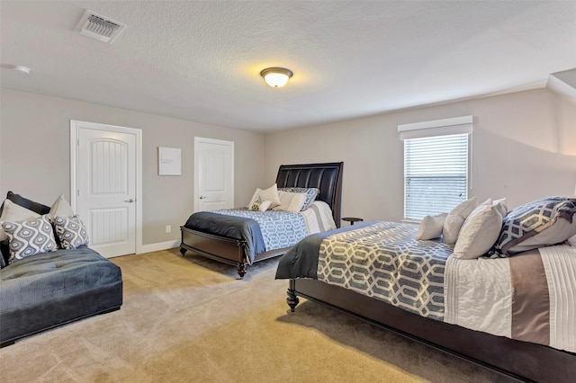 bedroom featuring a textured ceiling and light colored carpet